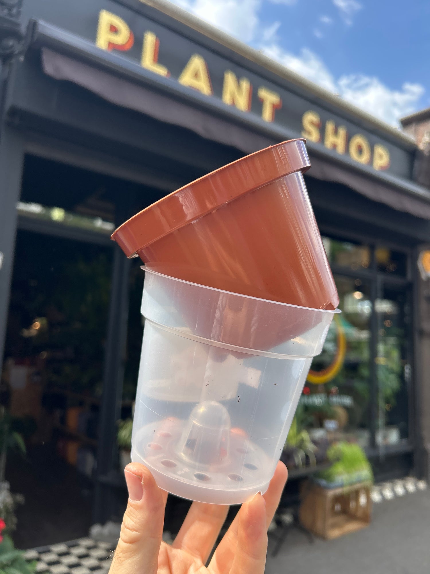 Clear and terracotta plastic nursery pots in front of Urban Tropicana’s Plant Shop in Chiswick London