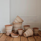 Stack of bergs potter pots on a wooden floor against a white wall