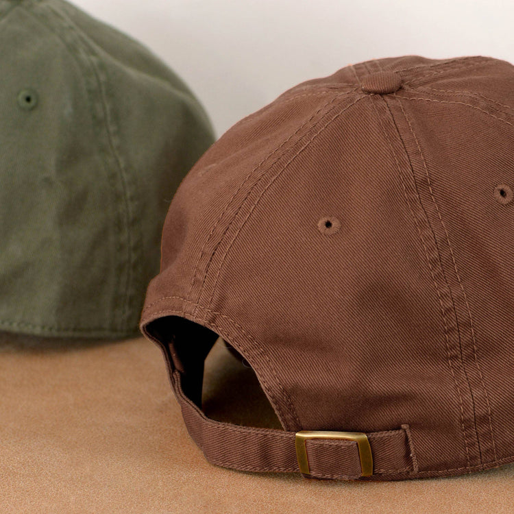 Cocoa Cotton Baseball Cap with ‘Bakery Tourist’ Text on a Neutral Background