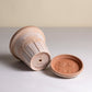Ceramic container with lid on a neutral background