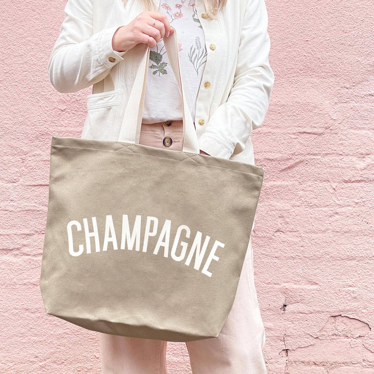 Stone Canvas Tote Bag with ‘Champagne’ text on a Pink Background