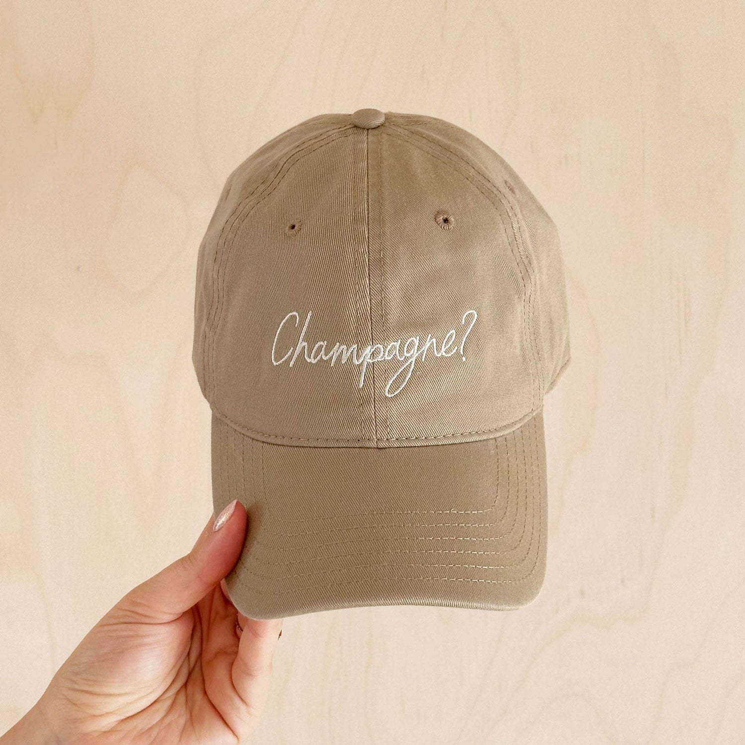 Cotton Baseball Cap with ‘Champagne?’ Text on a Neutral Background