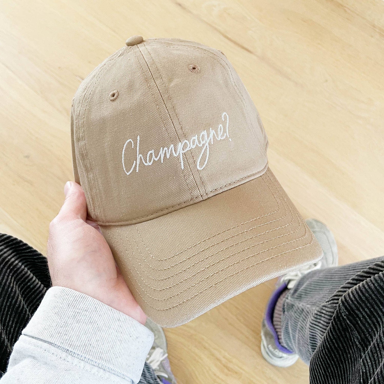 Cotton Baseball Cap with ‘Champagne?’ Text on a Neutral Background
