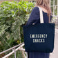 Person Wearing a Canvas Tote Bag with ‘Emergency Snacks’ Text on a Neutral Background