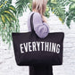 Person holding a black tote bag with &