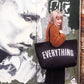 Person holding a black tote bag with &