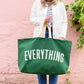 Person holding a green tote bag with &