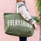Person holding a green tote bag with &