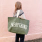 Person holding a green tote bag with &