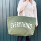 Person holding a green tote bag with &