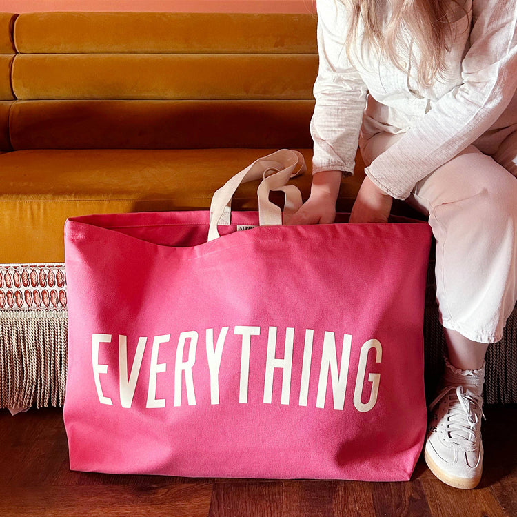 Bright Pink Really Big Bag with ‘Everything’ Text on a Neutral Background
