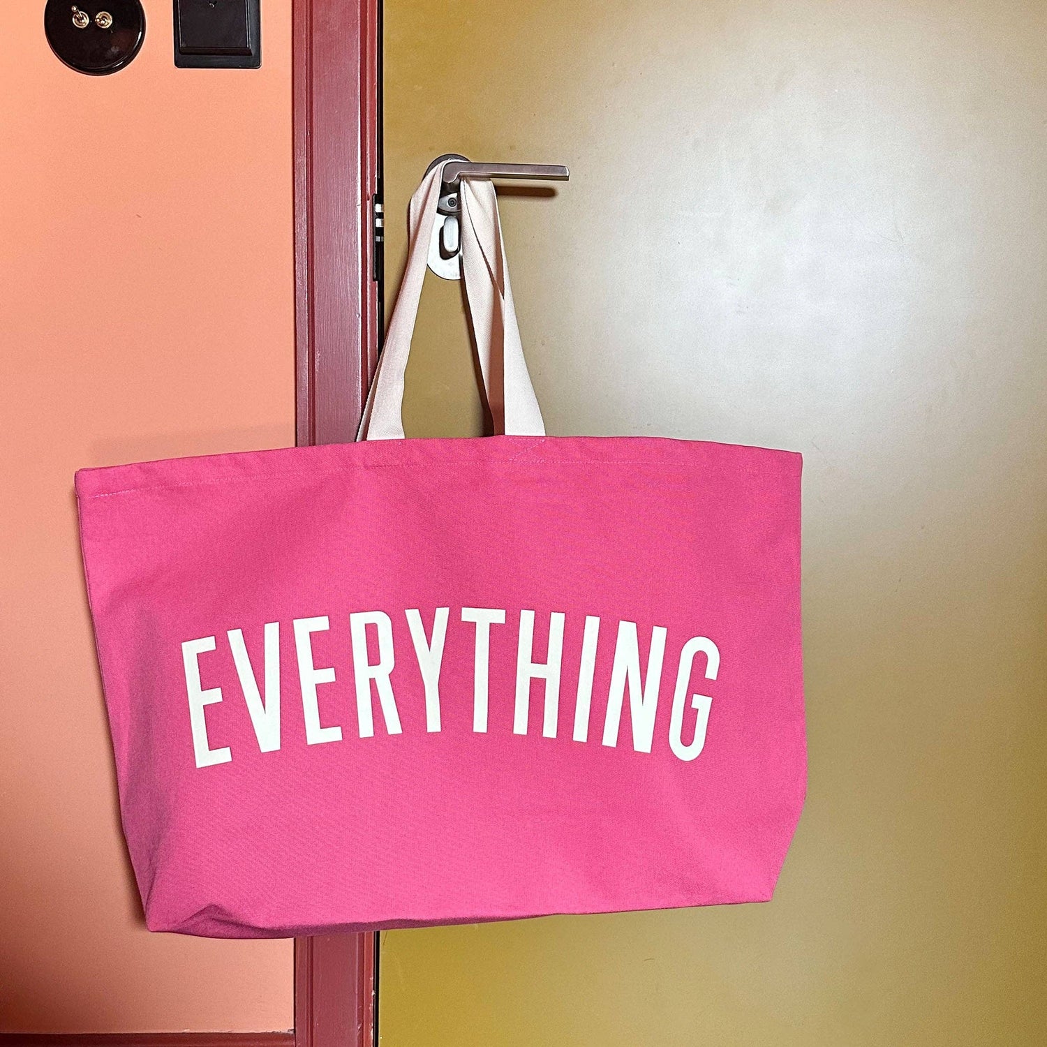 Bright Pink Really Big Bag with ‘Everything’ Text on a Neutral Background