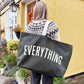 Person Carrying a Grey Really Big Bag with ‘Everything’ Text on a Mixed Background