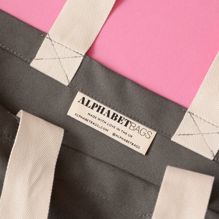 Grey Really Big Bag with ‘Everything’ Text on a Pink Background