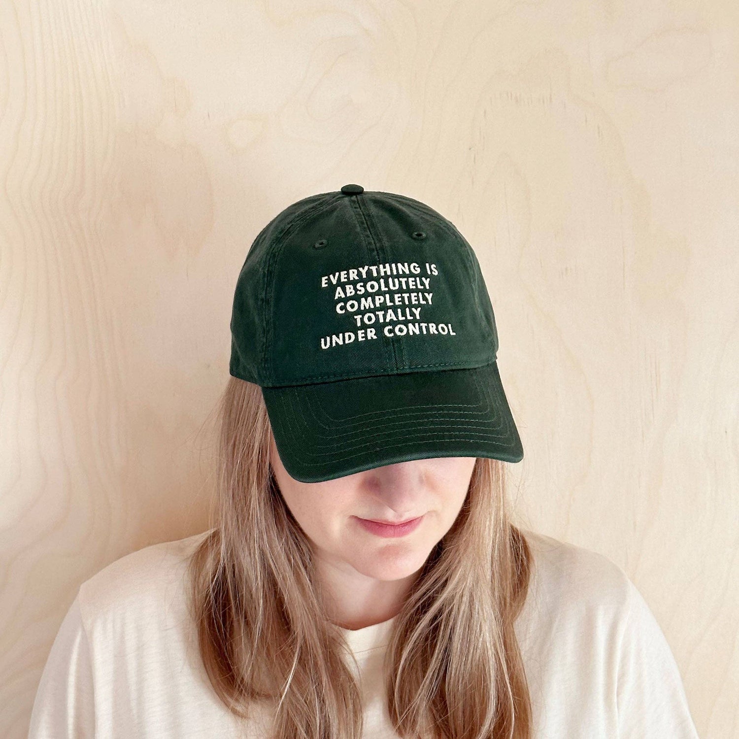 Person wearing a Cotton Baseball Cap with ‘Everything is Under Control’ text on a white  Background
