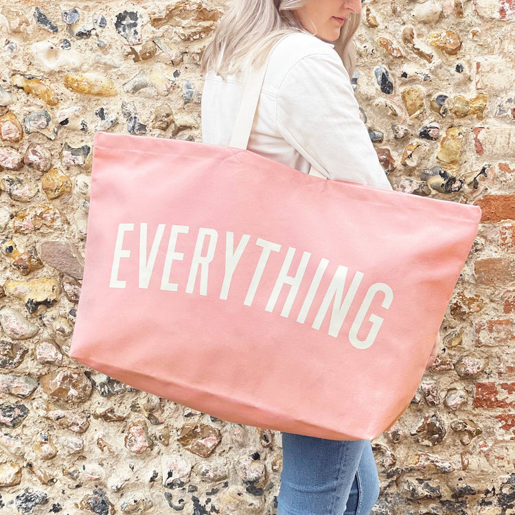 Person Carrying a Really Big Bag with ‘Everything’ Text on a Neutral Background