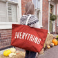Person Carrying a Rust Really Big Bag with ‘Everything’ Text on a Halloween Background