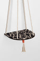 Hanging macrame plant shelf that rests neatly against the wall. Bold and graphic black and white print with natural white macrame twine and brass plated hoops. Made in England. 