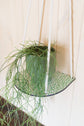 Hanging macrame plant shelf that rests nearly against the wall. ‘Forget me not’ green and white floral print with colourful twine, brass plated hoops and crimp bars. Made in England. 