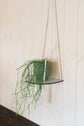 Hanging macrame plant shelf that rests nearly against the wall. ‘Forget me not’ green and white floral print with colourful twine, brass plated hoops and crimp bars. Made in England. 