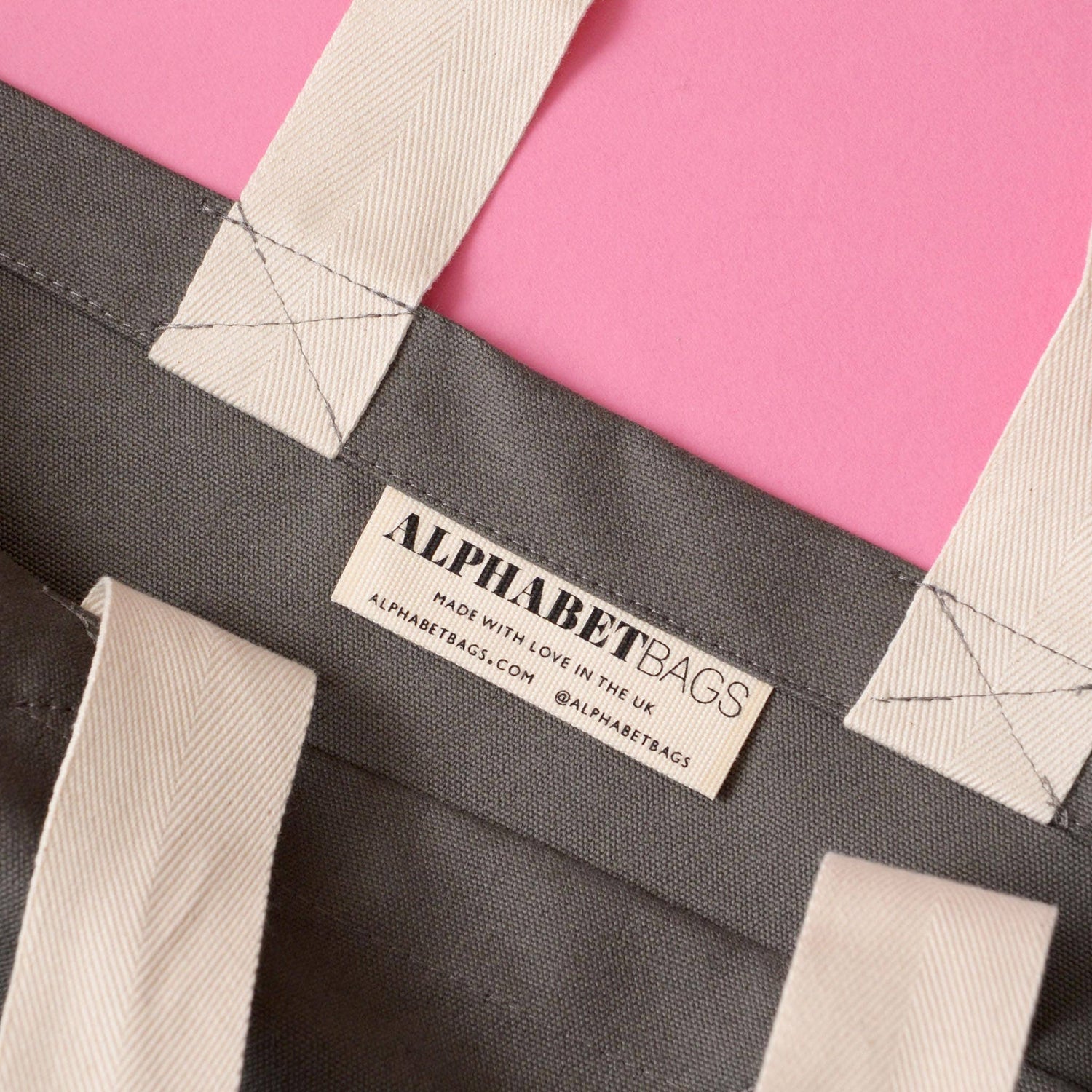 Grey Tote Bag with ‘I Think I Need More Coffee’ Text on a Pink Background