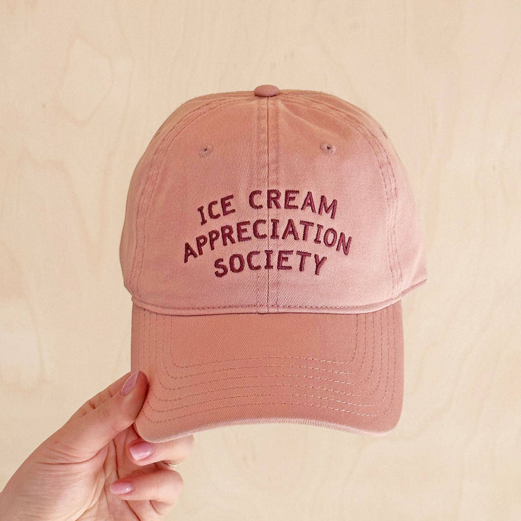 Dusty Rose Cotton Baseball Cap with ‘Ice Cream Appreciation Society’ Text on a Neutral Background