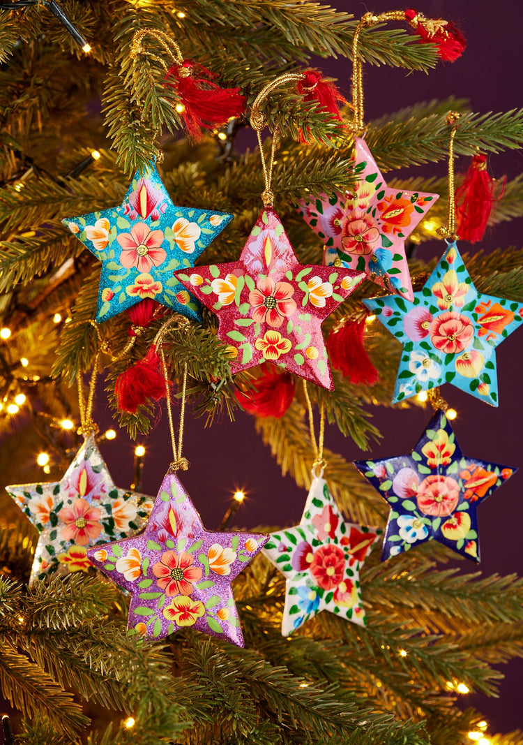 Colorful star-shaped Christmas ornaments on a tree with lights.