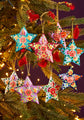 Colorful star-shaped Christmas ornaments on a tree with lights.