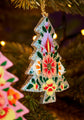 Decorative Christmas tree ornament with floral patterns hanging on a tree.
