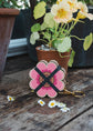 Attached to a lobster-claw Keyring, a pocket flower press that is a perfect size to press and dry flowers on the go. Flower-shaped in pink qnd yellow.. Strong elastic bands, 5 sheets of corrugated card and 8 sheets of sugar paper to ensure good pressing. 