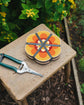 Pocket flower press that is a perfect size to press and dry flowers on the go. Flower-shaped in orange qnd yellow.. Strong elastic bands, 6 sheets of corrugated card and 10 sheets of sugar paper to ensure good pressing. 