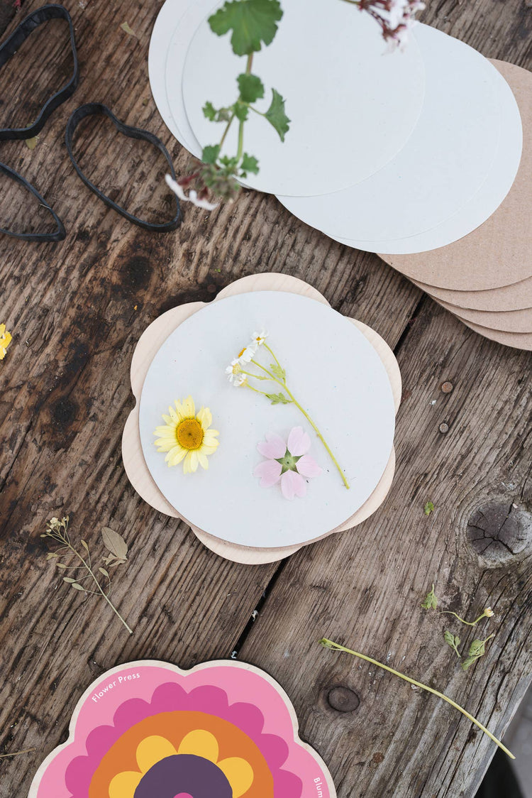 Pocket flower press that is a perfect size to press and dry flowers on the go. Flower-shaped in pink qnd yellow.. Strong elastic bands, 6 sheets of corrugated card and 10 sheets of sugar paper to ensure good pressing. 