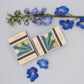 Pocket flower press that is a perfect size to press and dry flowers on the go. Blue, yellow and green dandelion print. Strong elastic bands, 5 sheets of corrugated card and 8 sheets of sugar paper to ensure good pressing. 
