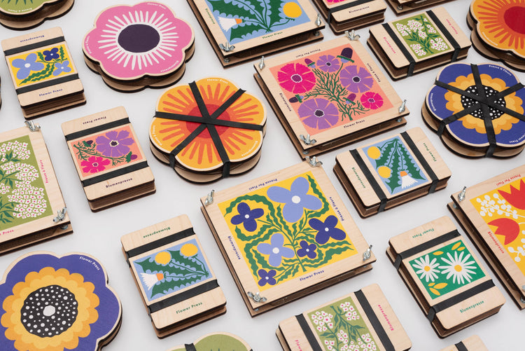 Pocket flower press that is a perfect size to press and dry flowers on the go. Blue, yellow and green dandelion print. Strong elastic bands, 5 sheets of corrugated card and 8 sheets of sugar paper to ensure good pressing. 