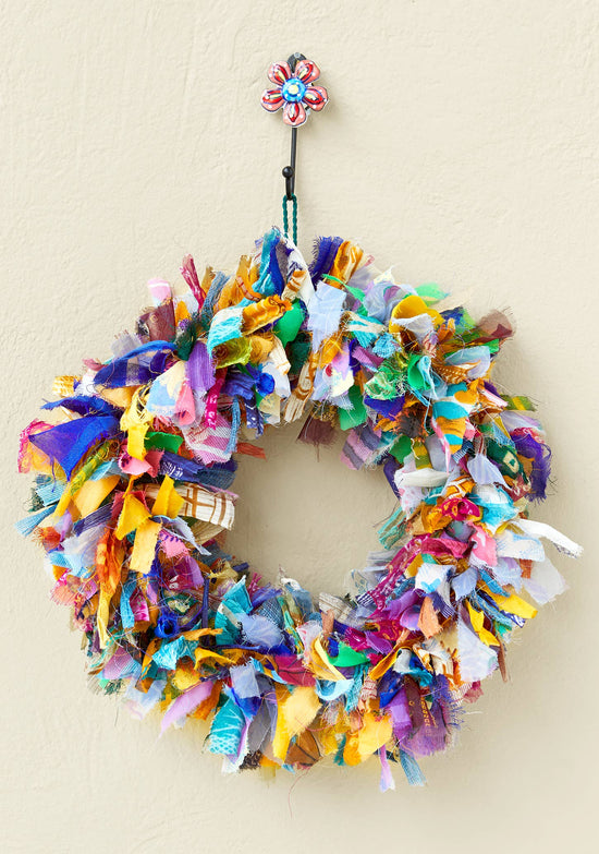 Colorful fabric wreath with a decorative hook on a beige background