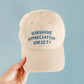 Off-White Cotton Baseball Cap with ‘Sunshine Appreciation Society’ text on a Neutral Background