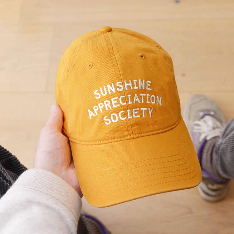Cotton Baseball Cap with ‘Sunshine Appreciation Society’ text on a Yellow Background