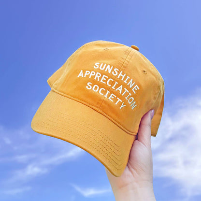 Cotton Baseball Cap with ‘Sunshine Appreciation Society’ text on a Sky Background
