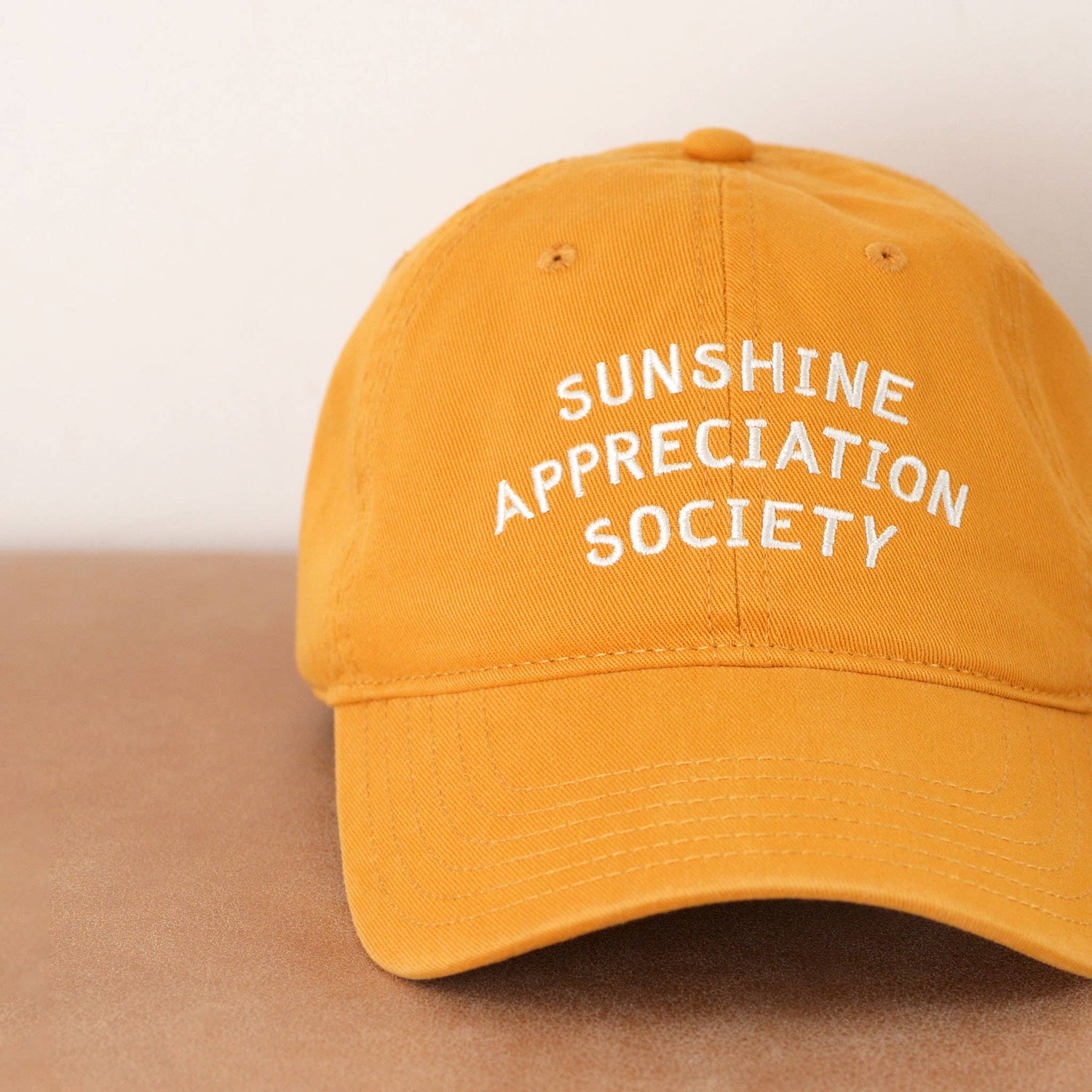Cotton Baseball Cap with ‘Sunshine Appreciation Society’ text on a Neutral Background