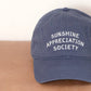 Vintage Blue Cotton Baseball Cap with ‘Sunshine Appreciation Society’ Text on a Neutral Background