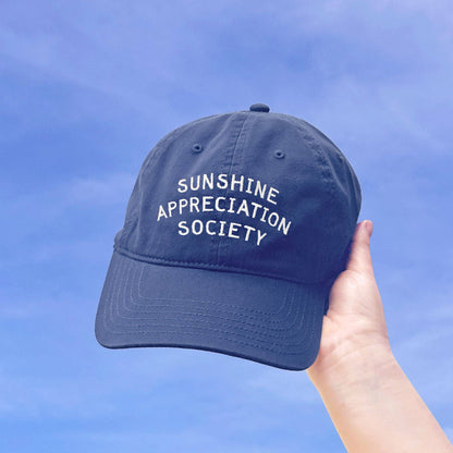 Vintage Blue Cotton Baseball Cap with ‘Sunshine Appreciation Society’ Text on a Sky Background