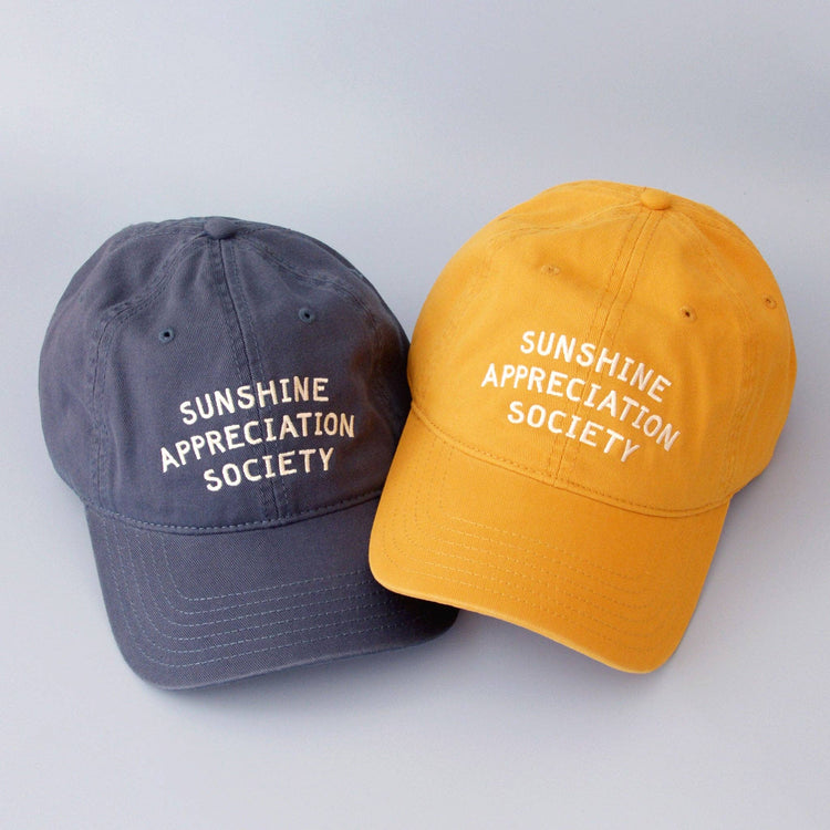 Vintage Blue Cotton Baseball Cap with ‘Sunshine Appreciation Society’ Text on a Blue Background