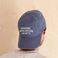 Person Wearing a Vintage Blue Cotton Baseball Cap with ‘Sunshine Appreciation Society’ Text on a Neutral Background