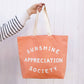 Peach Canvas Tote Bag with ‘Sunshine Appreciation Society’ text on a White Background