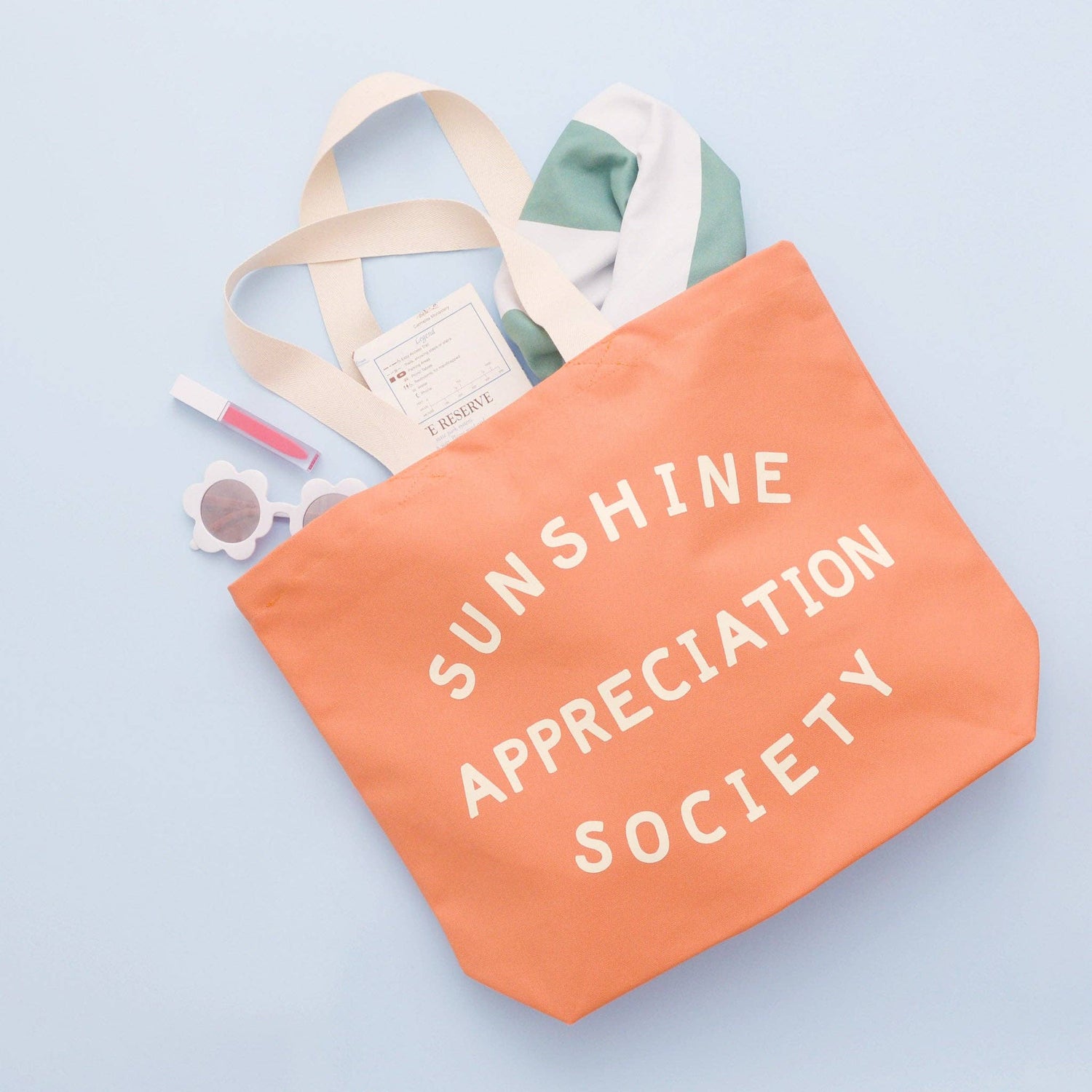 Peach Canvas Tote Bag with ‘Sunshine Appreciation Society’ text on a Blue Background