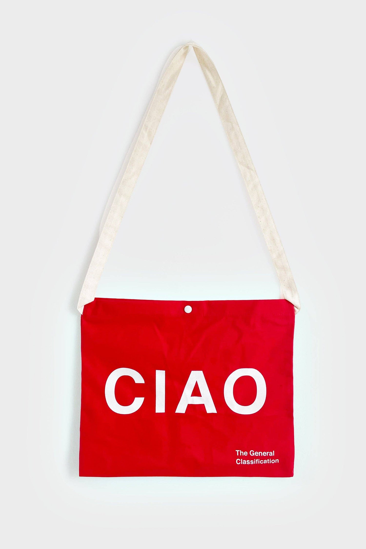Red reusable canvas tote bag with white handles and bold white "Ciao" and ‘Arrivederci’ graphic by The General Classification. Eco-friendly cotton shopping bag with modern minimalist design, ideal for everyday use, groceries, travel, and casual fashion.