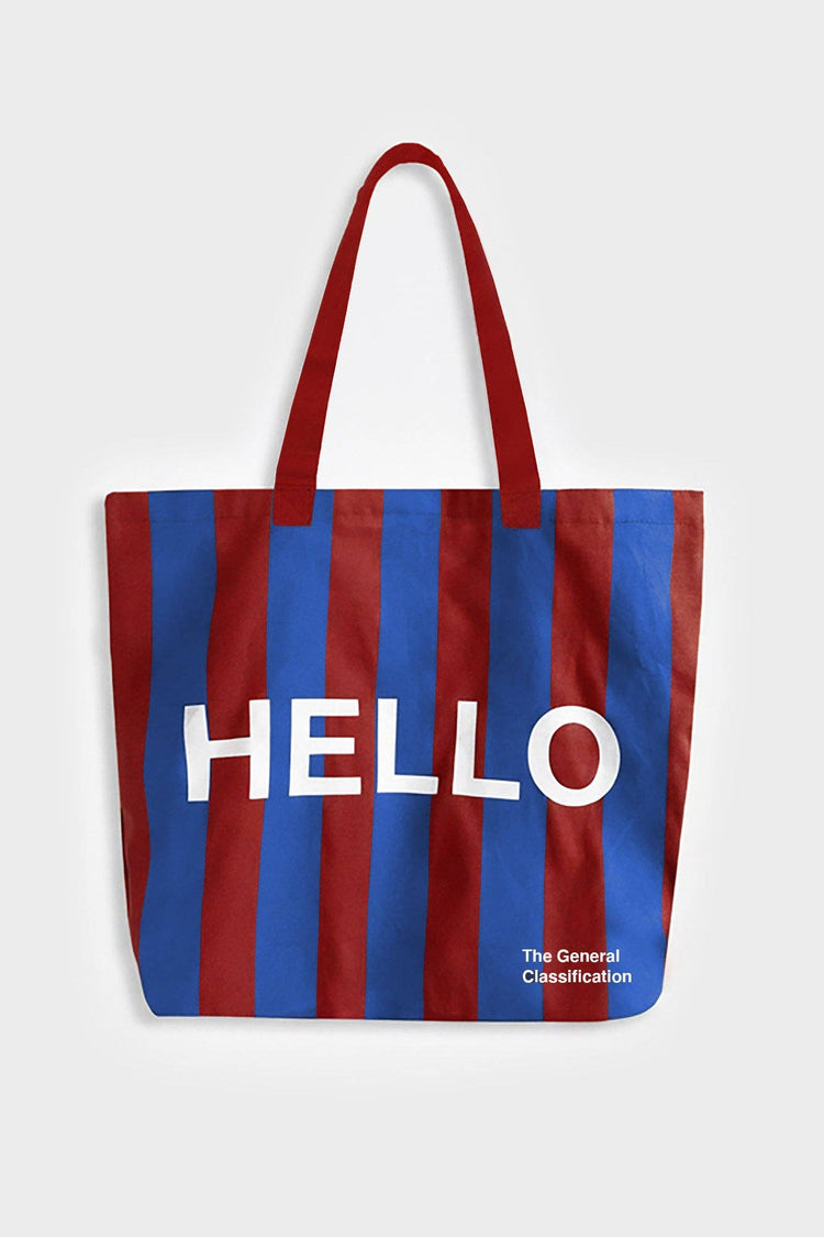 Red and navy stripe reusable canvas tote bag with red handles and bold white "Hello" and ‘Goodbye’ graphic by The General Classification. Eco-friendly cotton shopping bag with modern minimalist design, ideal for everyday use, groceries, travel, and casual fashion.