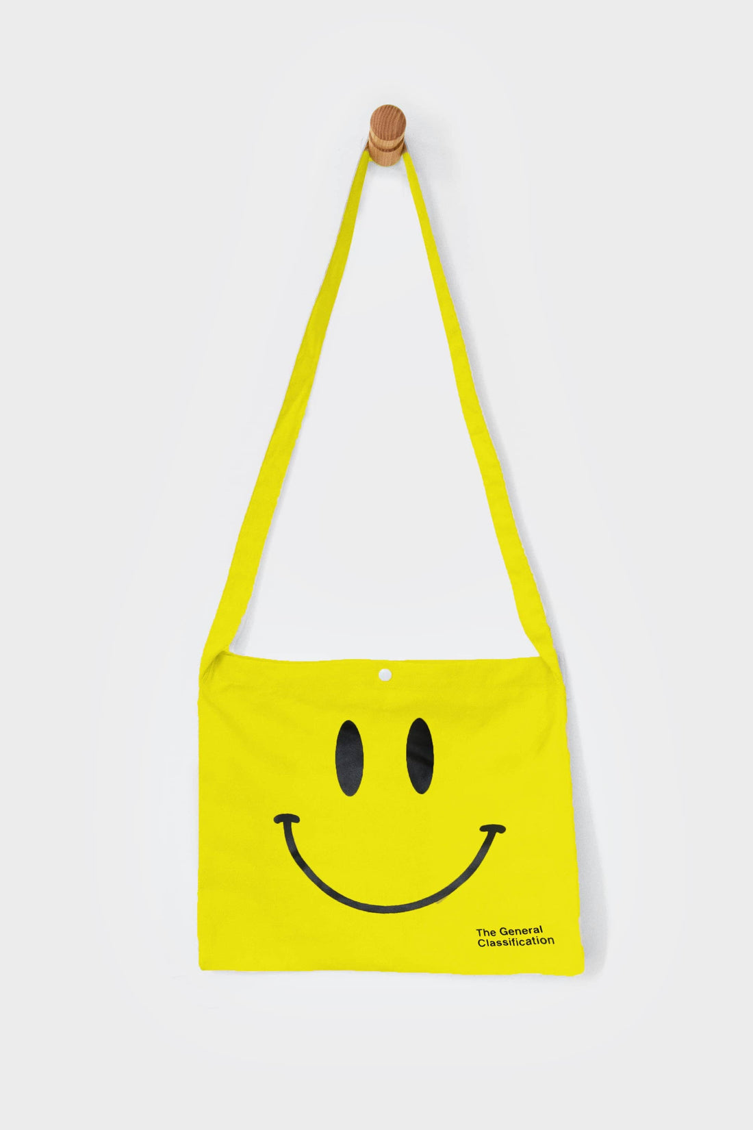 Yellow reusable canvas tote bag with yellow handles and bold black "Smiley Musette" graphic by The General Classification. Eco-friendly cotton shopping bag with modern minimalist design, ideal for everyday use, groceries, travel, and casual fashion.