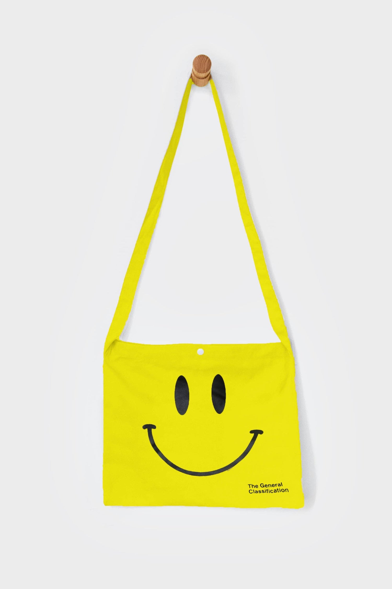 Yellow reusable canvas tote bag with yellow handles and bold black "Smiley Musette" graphic by The General Classification. Eco-friendly cotton shopping bag with modern minimalist design, ideal for everyday use, groceries, travel, and casual fashion.