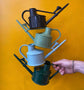 Haws - Langley Sprinker Watering Can in recycled, Sage, Blue and Green in front of a yellow background